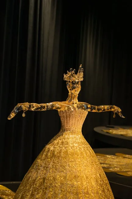 Sculpture en verre doré représentant une robe exposée sur fond noir