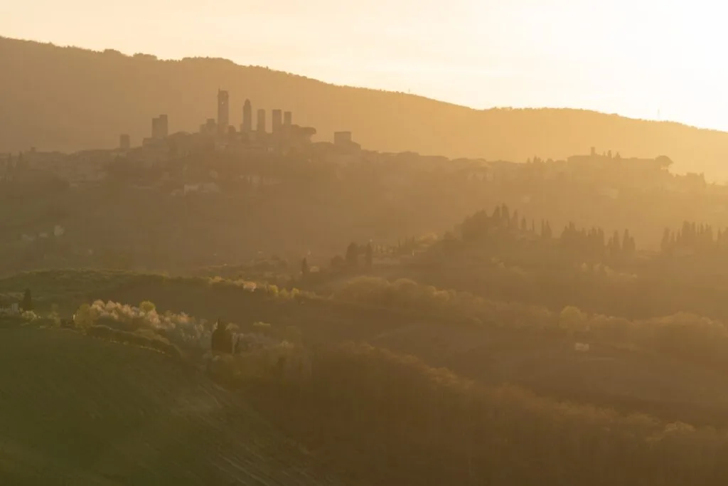 Silhouette dorée de collines et tours toscanes autour de Sienne