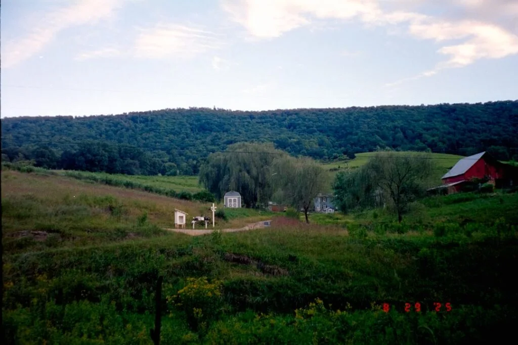 Collines verdoyantes et ferme rouge au loin près de Sienne
