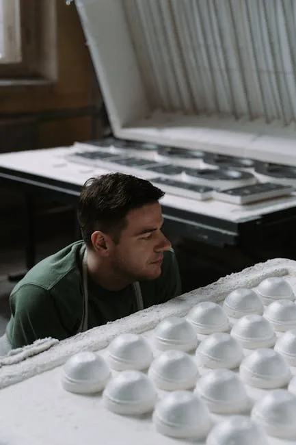 Jeune potier regardant des pièces blanches prêtes dans un four, atelier près de Sienne
