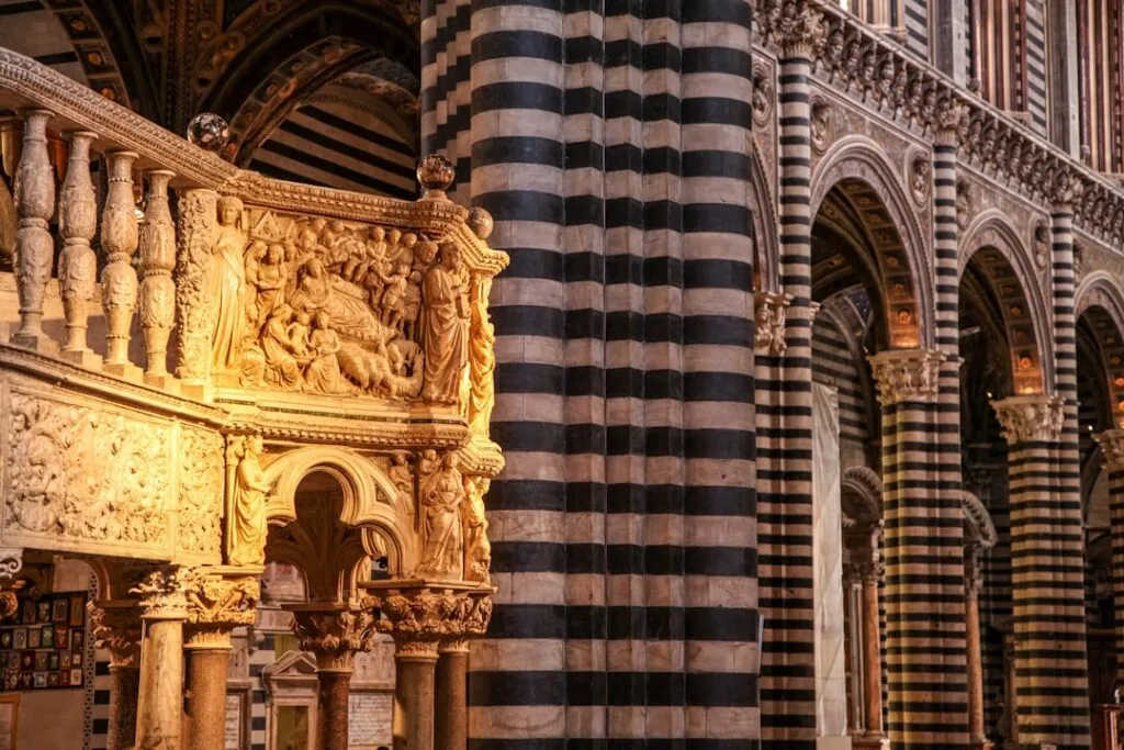 Gedetailleerd marmeren preekstoel en zwart-wit zuilen in de Duomo van Siena
