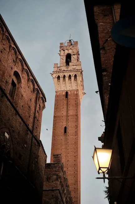 Torre del Mangia ragt zwischen engen Gassen in Siena empor