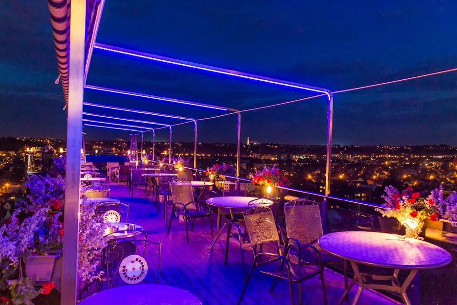Terrasse sur toit éclairée de néons, vue nocturne sur Sienne