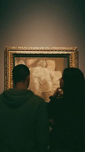 Deux visiteurs contemplent un tableau religieux encadré dans un musée de Sienne