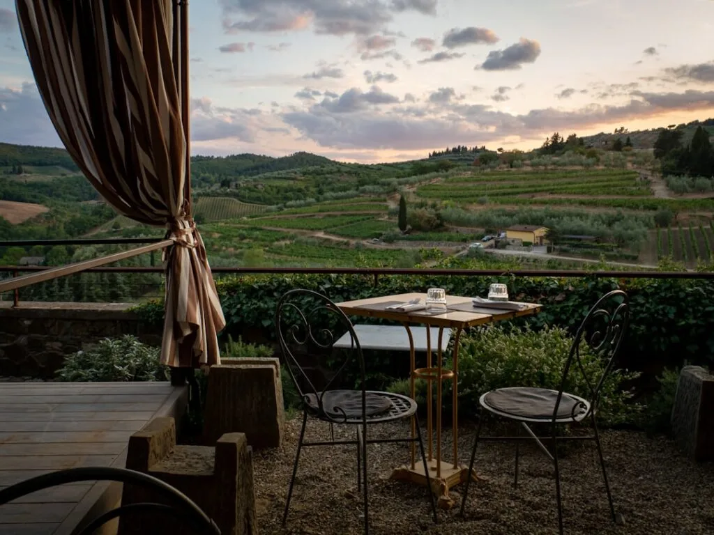 Terrasse de restaurant avec vue sur vignobles au coucher du soleil près de Sienne.