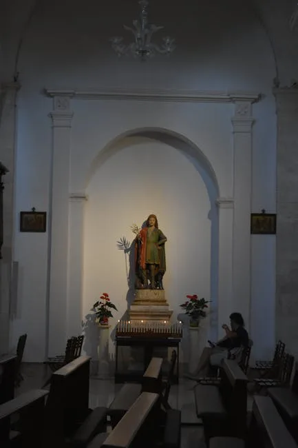 Niche d'autel avec statue de saint et bougies dans une église de Sienne
