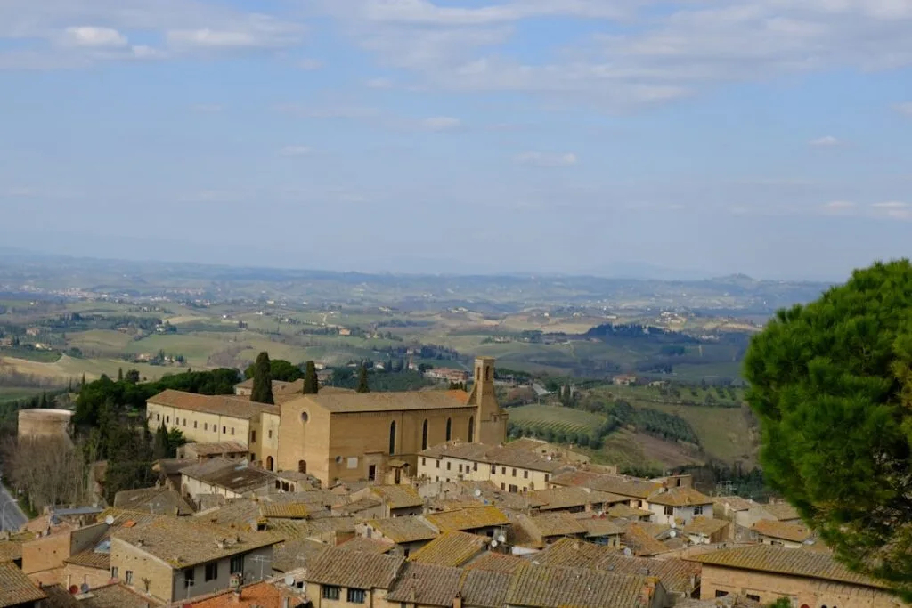Panorama depuis San Gimignano avec église, toits et collines toscanes