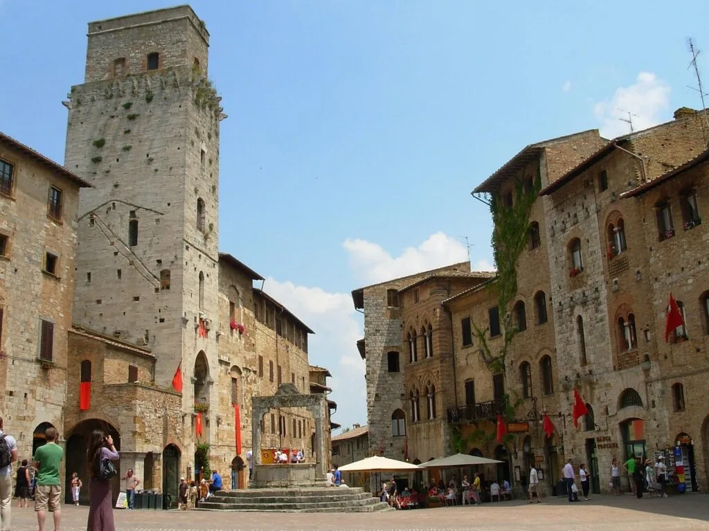 Place médiévale animée à San Gimignano avec puits central