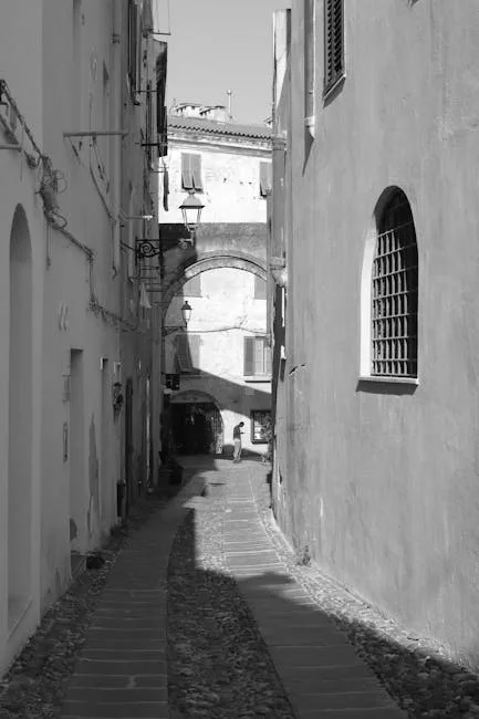 Ruelle pavée à Sienne avec arche et passante en silhouette