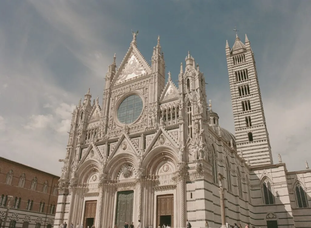 Fassade und gestreifter Campanile des Duomo von Siena vor Himmel