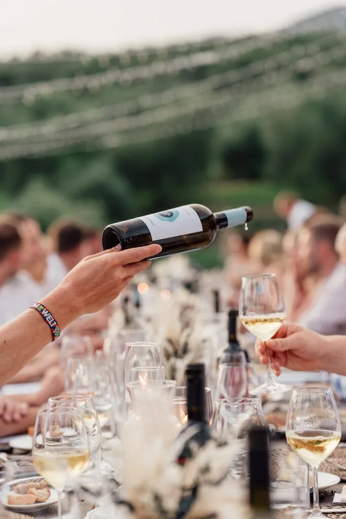 Versement de vin blanc lors d'un dîner en plein air dans les vignes