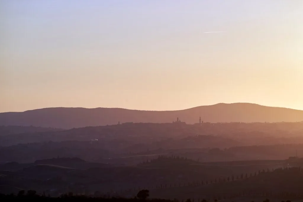 Silhouette de Sienne et collines toscanes au coucher du soleil
