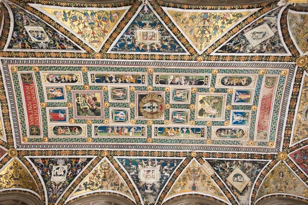 Plafond peint richement orné de panneaux décorés dans le Duomo de Sienne