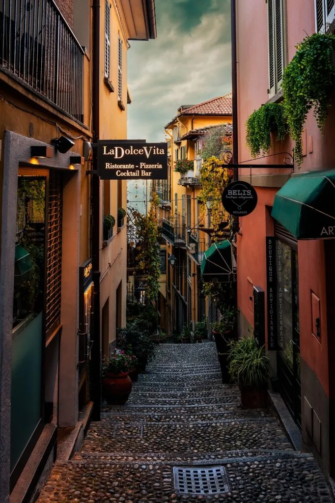 Ruelle pavée à Sienne bordée de boutiques et enseignes