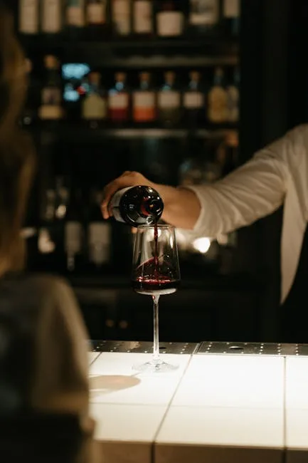 Serveur versant un verre de vin rouge lors d'une dégustation à Sienne