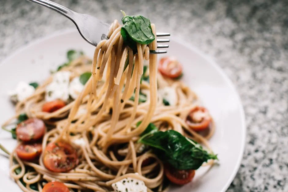 Assiette de spaghetti aux tomates cerises et basilic, spécialité dégustée à Sienne