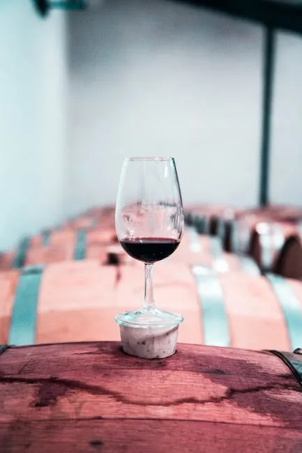 Verre de vin rouge de Montepulciano posé sur un tonneau dans une cave