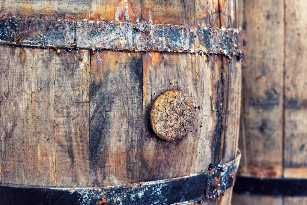 Gros plan sur une vieille barrique de vin en bois avec cerceaux rouillés