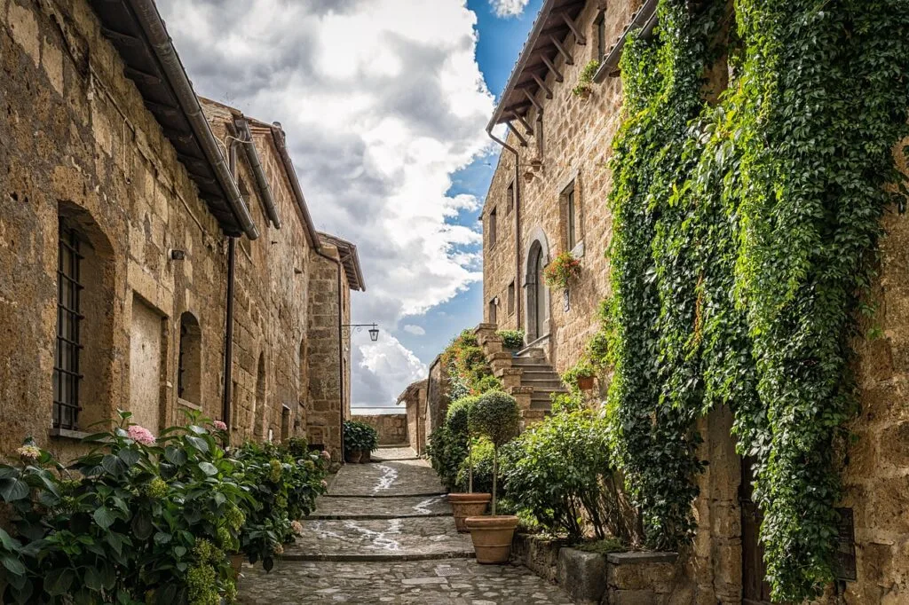 Ruelle pavée bordée de maisons en pierre et de plantes en pot