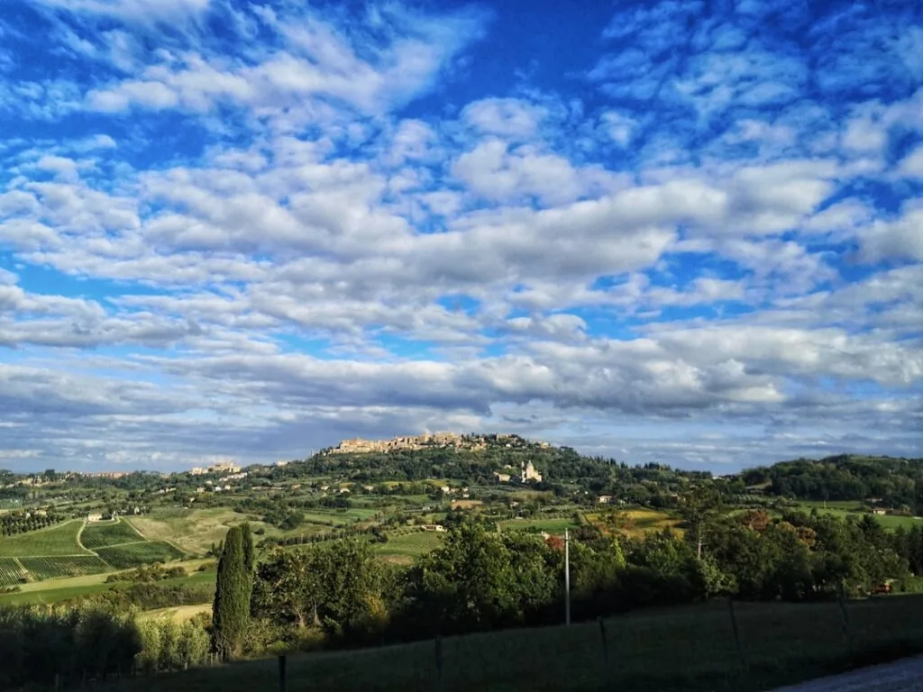 Panorama vallonné avec village perché de Montepulciano sous un ciel nuageux