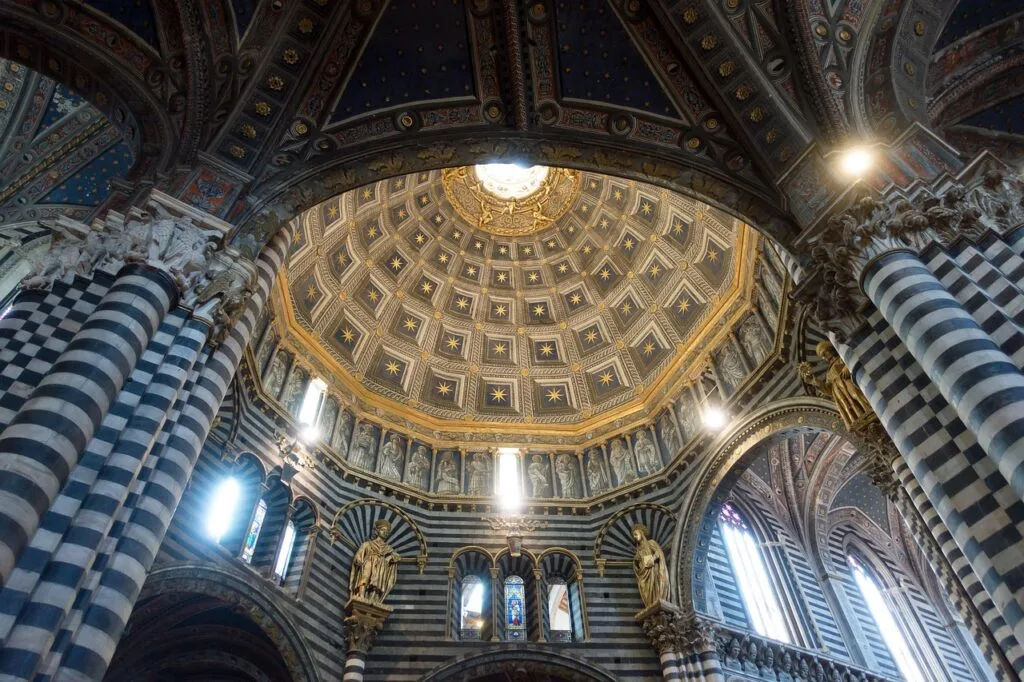 Dôme étoilé et colonnes rayées à l'intérieur du Duomo de Sienne