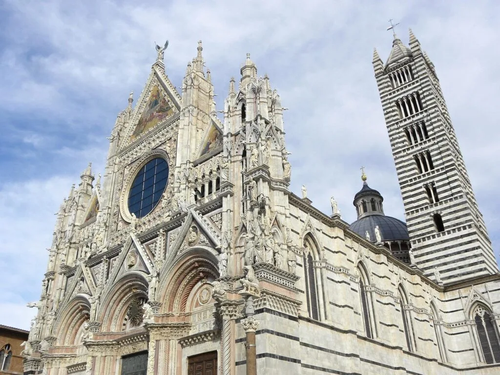 Façade richement sculptée du Duomo de Sienne et son campanile rayé