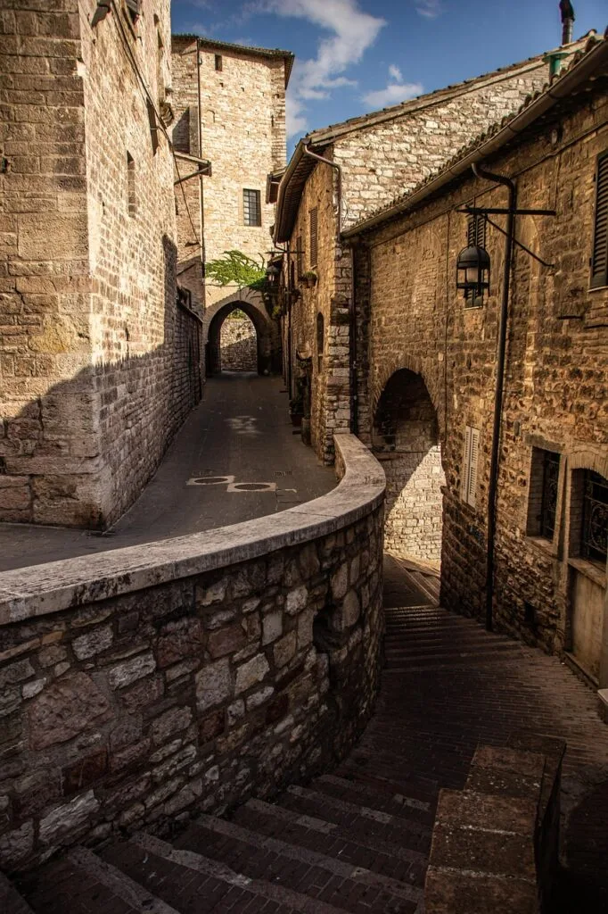 Ruelle médiévale en pierre à Sienne avec arcades et escaliers