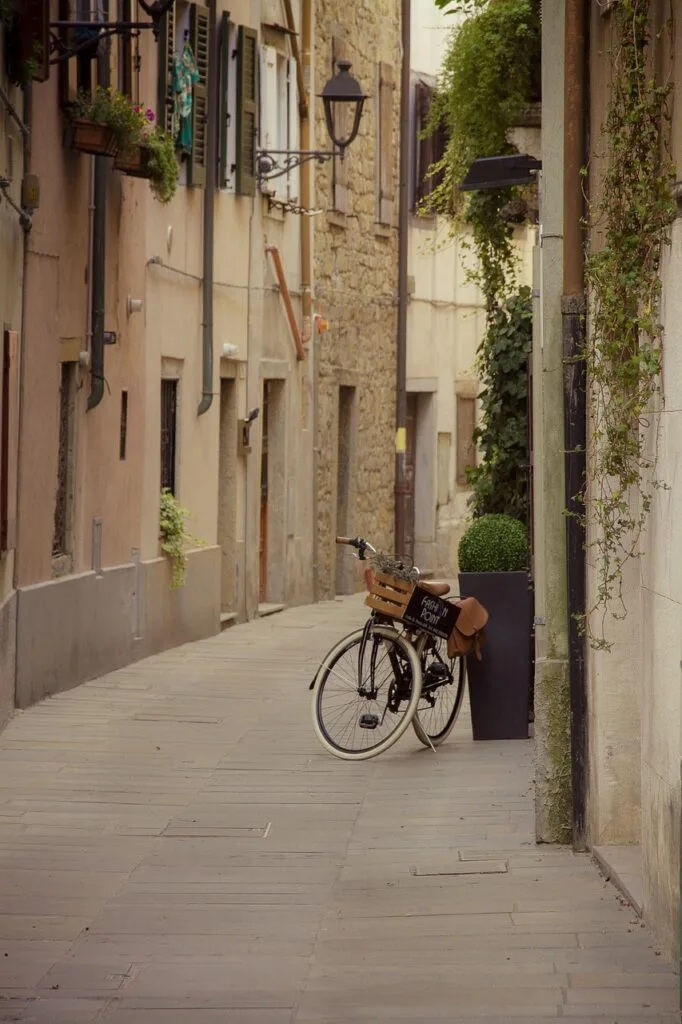 Ruelle intime de Sienne avec un vélo appuyé contre un pot